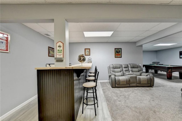 bar featuring billiards, light hardwood / wood-style flooring, and a drop ceiling