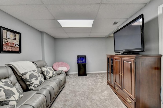 carpeted living room featuring a drop ceiling