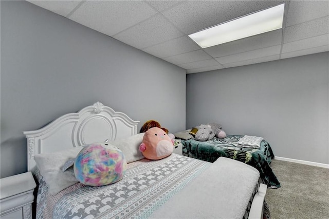 carpeted bedroom featuring a drop ceiling