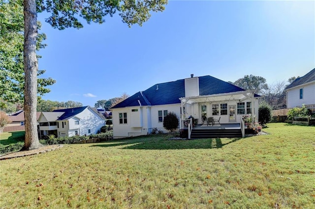 back of house featuring a wooden deck, a pergola, and a yard