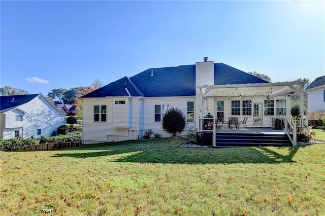 back of property with a wooden deck, a lawn, and a pergola