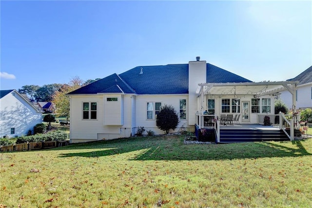 rear view of property featuring a pergola, a deck, and a lawn