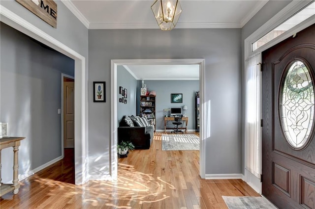 foyer featuring hardwood / wood-style flooring, crown molding, and a notable chandelier