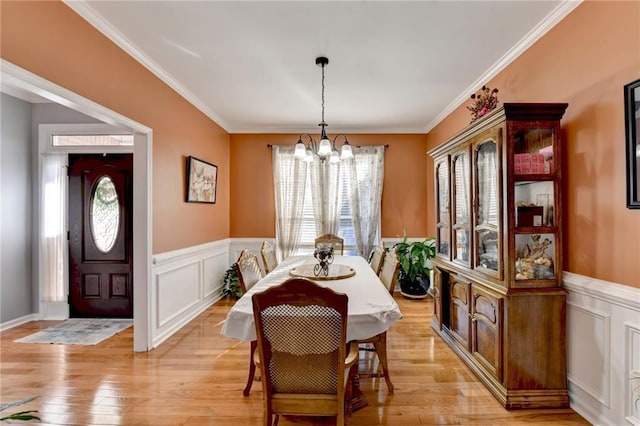 dining area featuring a notable chandelier, light hardwood / wood-style flooring, and ornamental molding