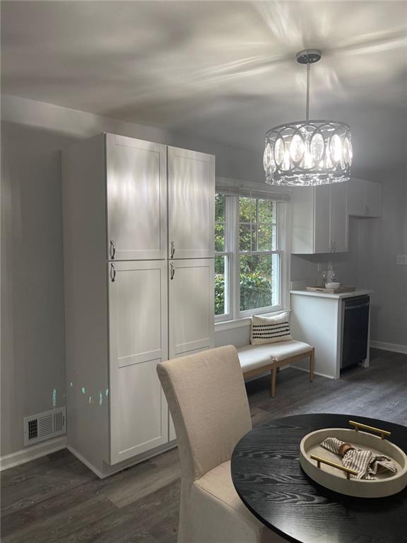 2135 Niskey Lake Rd SW, Atlanta, GA 30331 - dining area with baseboards, visible vents, wood finished floors, and an inviting chandelier