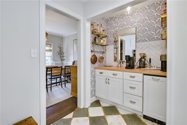 kitchen featuring tasteful backsplash, white cabinetry, wooden counters, crown molding, and light wood-type flooring