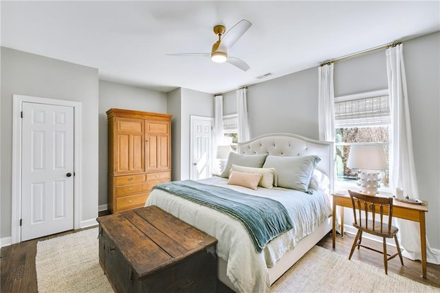 bedroom with multiple windows, hardwood / wood-style flooring, and ceiling fan