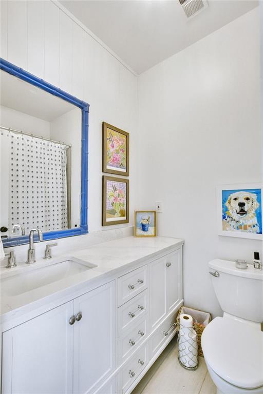 bathroom with a shower with curtain, vanity, and toilet