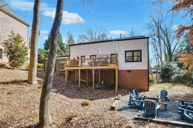 back of house featuring a deck and an outdoor fire pit