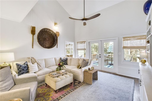 living room with wood-type flooring, ceiling fan, high vaulted ceiling, and french doors