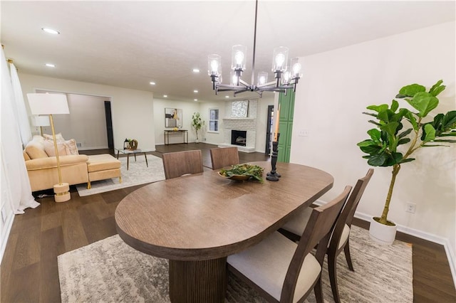 dining room with recessed lighting, dark wood-style flooring, a fireplace, and baseboards