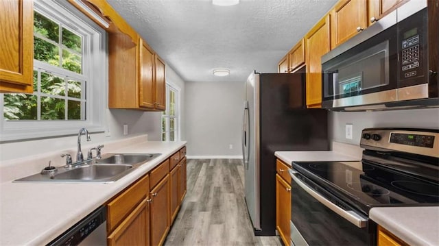 35 Ravenwood Dr, Rockmart, GA 30153 - kitchen featuring stainless steel appliances, plenty of natural light, light countertops, light wood-style floors, and a textured ceiling