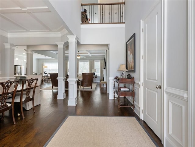 foyer with ceiling fan, dark wood-type flooring, and ornamental molding