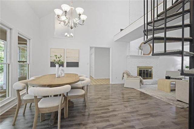 402 Roswell Green Ln, Roswell, GA 30075 - dining space featuring a chandelier, high vaulted ceiling, wood finished floors, a fireplace, and baseboards