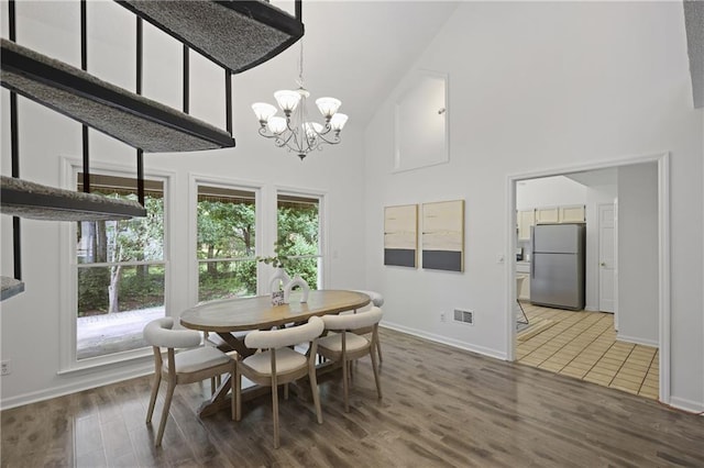 402 Roswell Green Ln, Roswell, GA 30075 - dining area with high vaulted ceiling, a chandelier, baseboards, and wood finished floors
