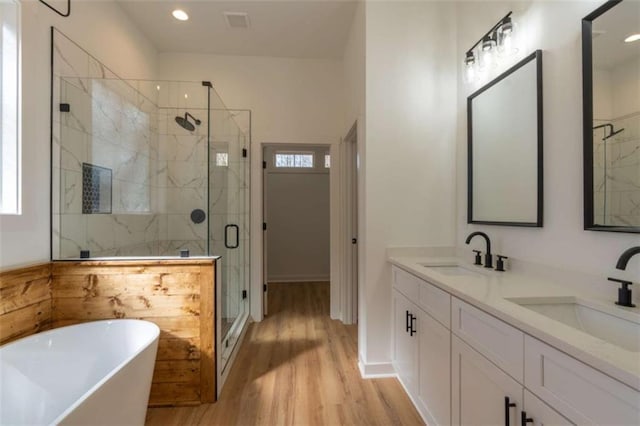 1250 Hays Mill Rd, Carrollton, GA 30117 - full bath featuring a freestanding tub, wood finished floors, a stall shower, double vanity, and recessed lighting