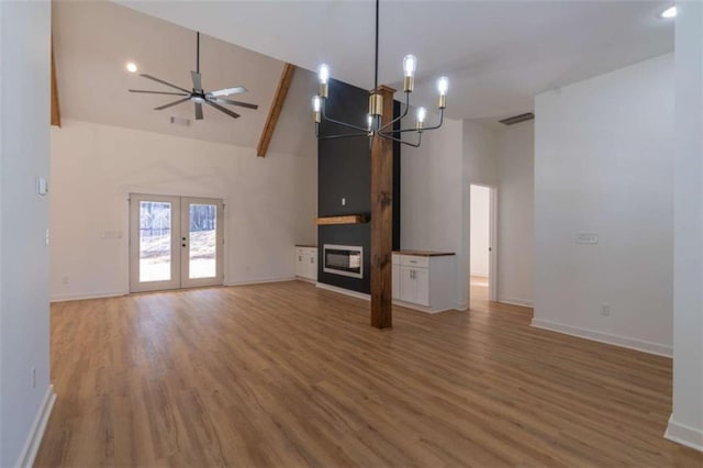 1250 Hays Mill Rd, Carrollton, GA 30117 - unfurnished living room with high vaulted ceiling, baseboards, light wood finished floors, a chandelier, and french doors