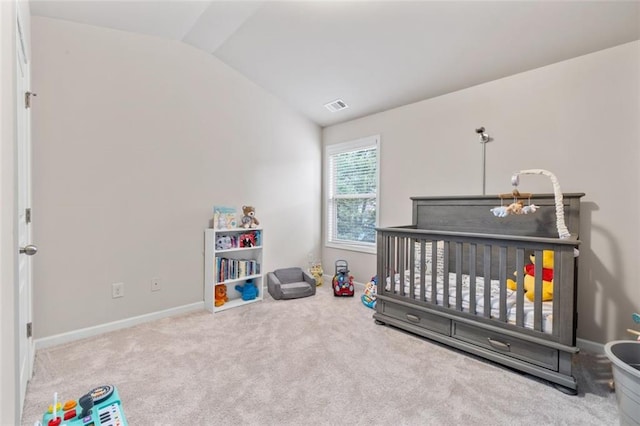 carpeted bedroom with lofted ceiling and a nursery area