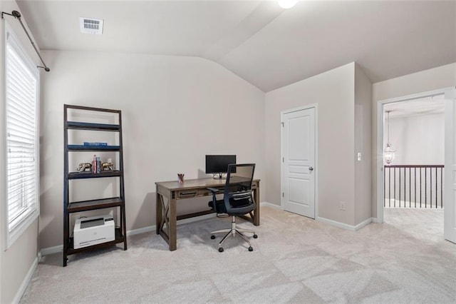 home office with light carpet, vaulted ceiling, and plenty of natural light