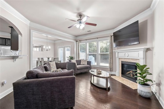 living room featuring ornamental molding, dark hardwood / wood-style flooring, and ceiling fan with notable chandelier