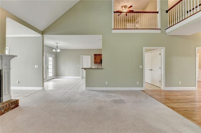 3426 Olivia Grace Way, Dacula, GA 30019 - unfurnished living room featuring high vaulted ceiling, light colored carpet, baseboards, ceiling fan, and a fireplace