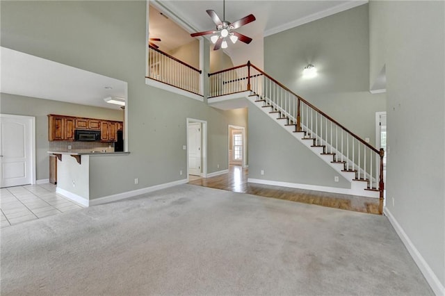 3426 Olivia Grace Way, Dacula, GA 30019 - unfurnished living room featuring a high ceiling, light colored carpet, ceiling fan, and baseboards