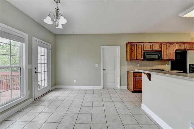 3426 Olivia Grace Way, Dacula, GA 30019 - kitchen featuring black microwave, refrigerator with ice dispenser, baseboards, decorative backsplash, and a chandelier