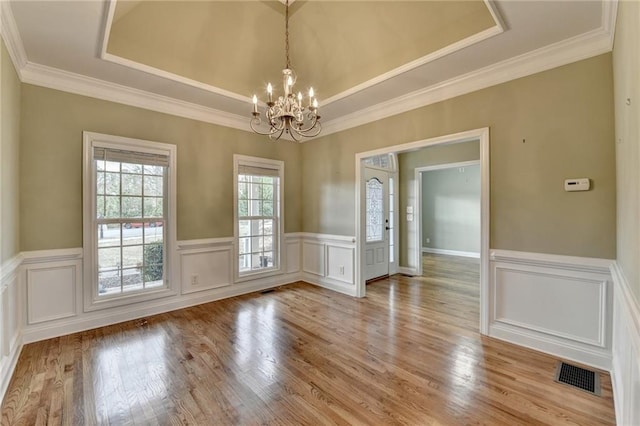 3426 Olivia Grace Way, Dacula, GA 30019 - empty room with a chandelier, a raised ceiling, light wood-type flooring, wainscoting, and crown molding
