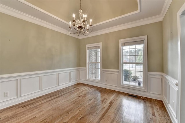 3426 Olivia Grace Way, Dacula, GA 30019 - spare room featuring a chandelier, a wainscoted wall, crown molding, a raised ceiling, and wood finished floors