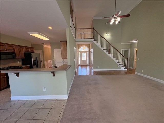 3426 Olivia Grace Way, Dacula, GA 30019 - kitchen featuring stainless steel refrigerator with ice dispenser, black microwave, a breakfast bar area, ceiling fan, and a peninsula