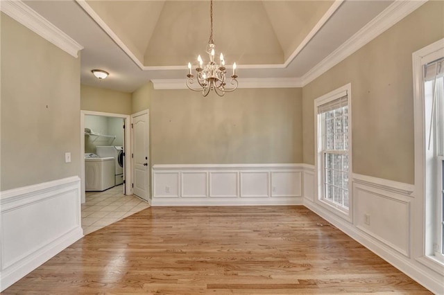 3426 Olivia Grace Way, Dacula, GA 30019 - unfurnished dining area with independent washer and dryer, a chandelier, crown molding, a wainscoted wall, and vaulted ceiling