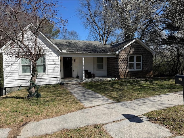 ranch-style home with brick siding, a porch, and a front lawn