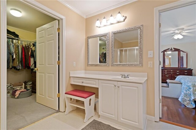 kitchen with white appliances, a center island with sink, sink, ceiling fan, and ornamental molding