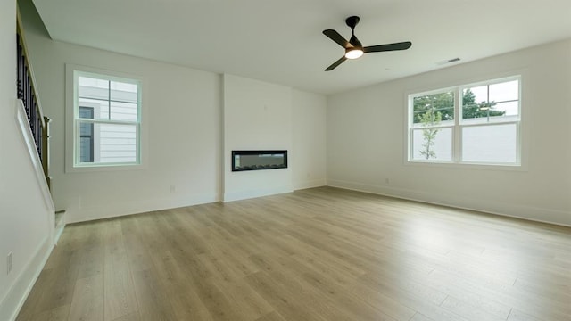 1514 Gatekeeper Ter, Marietta, GA 30066 - unfurnished living room featuring light wood-style floors, a glass covered fireplace, and baseboards
