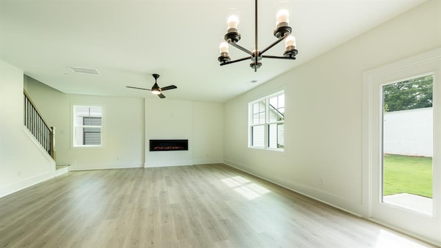 1514 Gatekeeper Ter, Marietta, GA 30066 - unfurnished living room with a chandelier, plenty of natural light, light wood-type flooring, and a ceiling fan