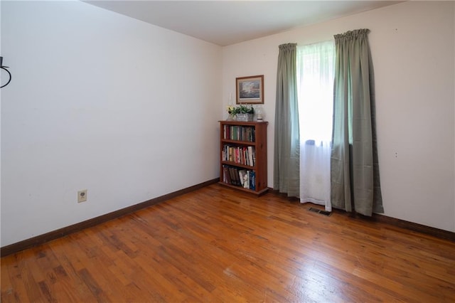 empty room with hardwood / wood-style flooring