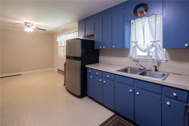 kitchen featuring light tile patterned flooring, stainless steel refrigerator, ceiling fan, blue cabinetry, and sink