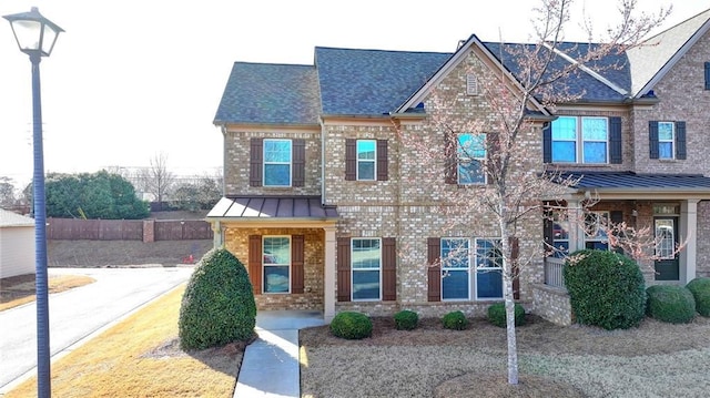 craftsman inspired home with metal roof, brick siding, and a standing seam roof