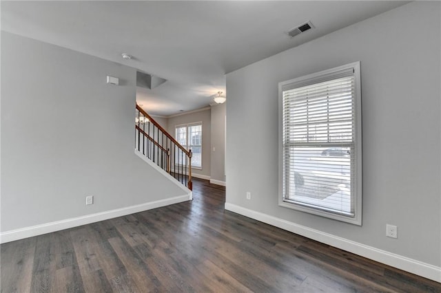 spare room with visible vents, dark wood finished floors, stairway, and baseboards