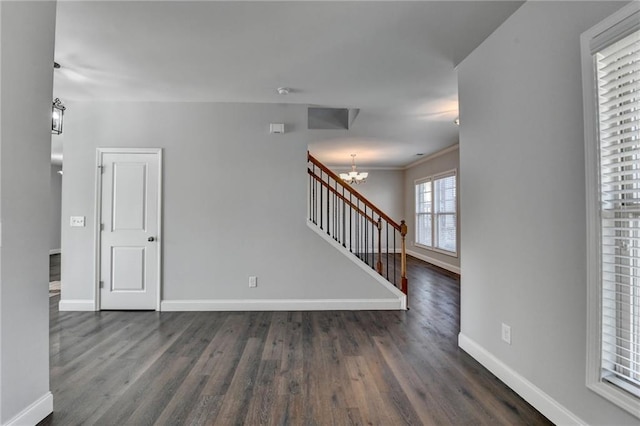 spare room with a chandelier, dark wood-type flooring, stairway, and baseboards