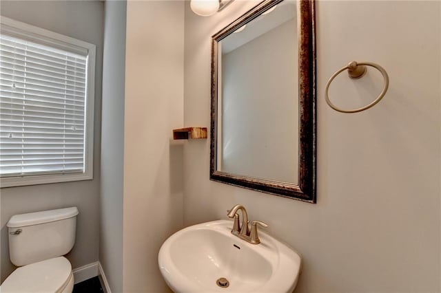 bathroom featuring a sink, toilet, and baseboards