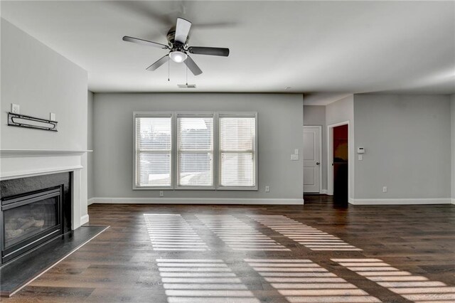 unfurnished living room with a fireplace, wood finished floors, visible vents, and baseboards