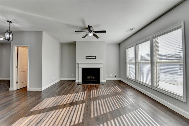 unfurnished living room with a fireplace with flush hearth, baseboards, and dark wood-style flooring