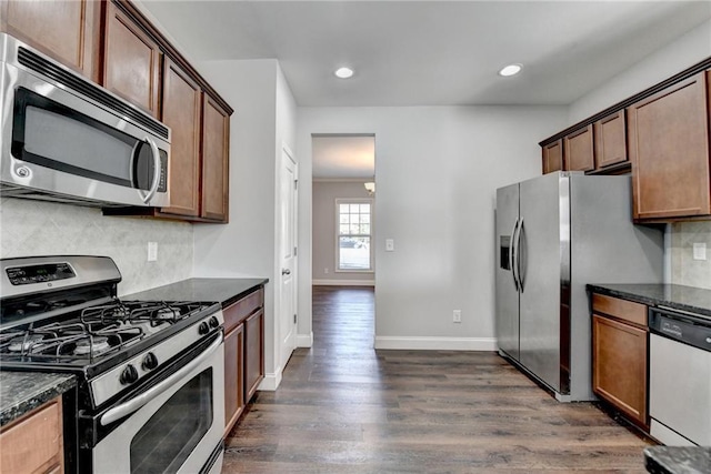 kitchen with recessed lighting, baseboards, appliances with stainless steel finishes, decorative backsplash, and dark wood-style floors