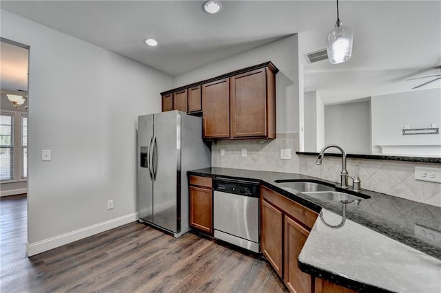 kitchen with visible vents, dark wood-style floors, appliances with stainless steel finishes, a sink, and backsplash