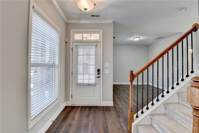 foyer featuring crown molding, visible vents, dark wood-type flooring, baseboards, and stairs