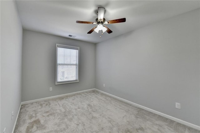 carpeted empty room with visible vents, ceiling fan, and baseboards