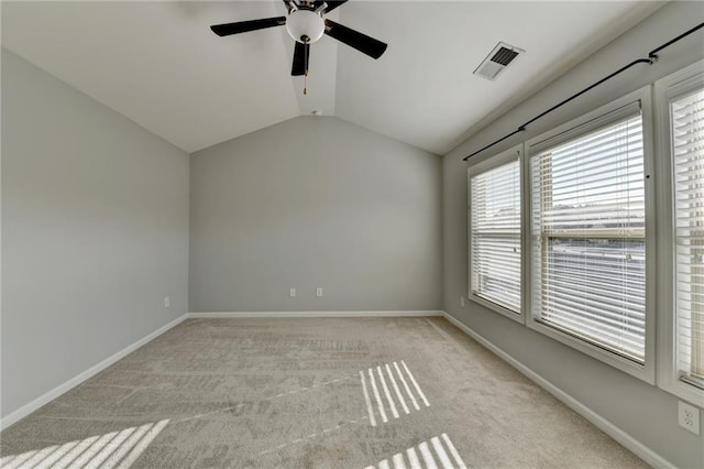 empty room with lofted ceiling, baseboards, light carpet, and visible vents