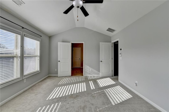 unfurnished bedroom with lofted ceiling, carpet flooring, visible vents, and baseboards