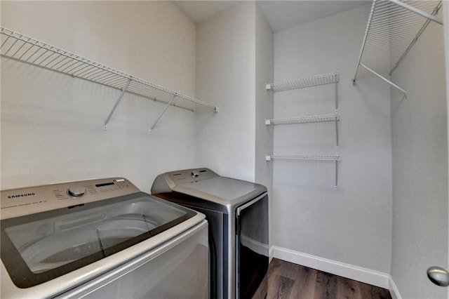 washroom featuring laundry area, independent washer and dryer, dark wood finished floors, and baseboards